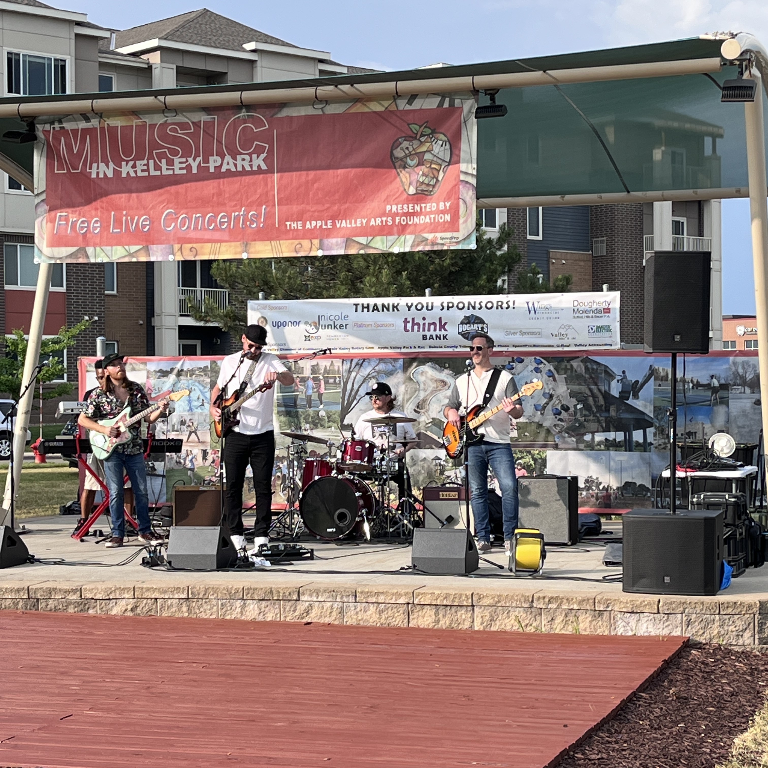 Band performing on stage at Music in Kelley Park concert sponsored by Think Bank