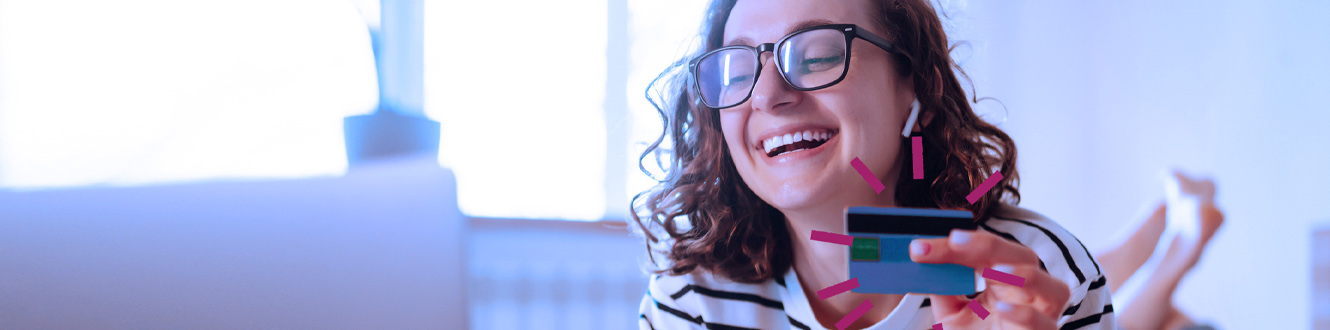 Person holding a debit card and smiling.